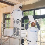 Zwei Männer dämmen ein Haus